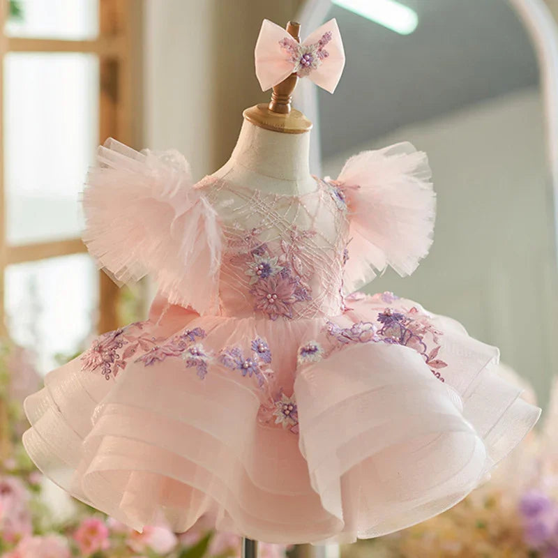 Delicate pink toddler dress with floral embroidery and tulle puff sleeves on mannequin
