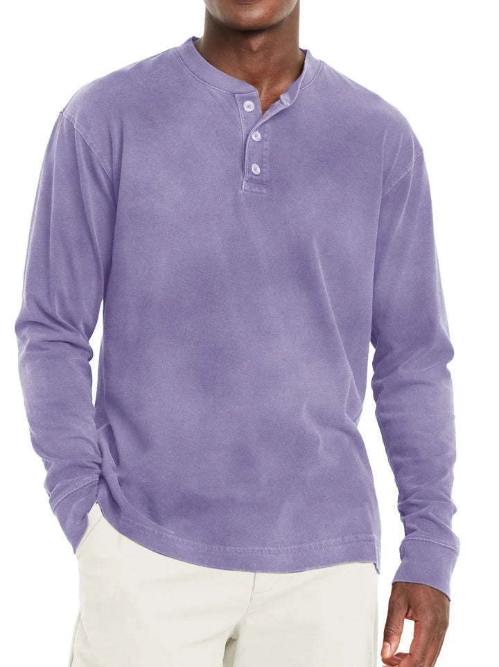 male model wearing lavender long sleeve henley shirt with three buttons and beige pants