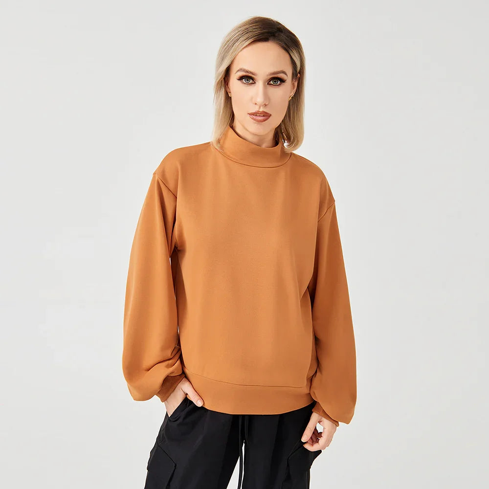 Woman wearing brown high-neck sweatshirt with black cargo pants on light background