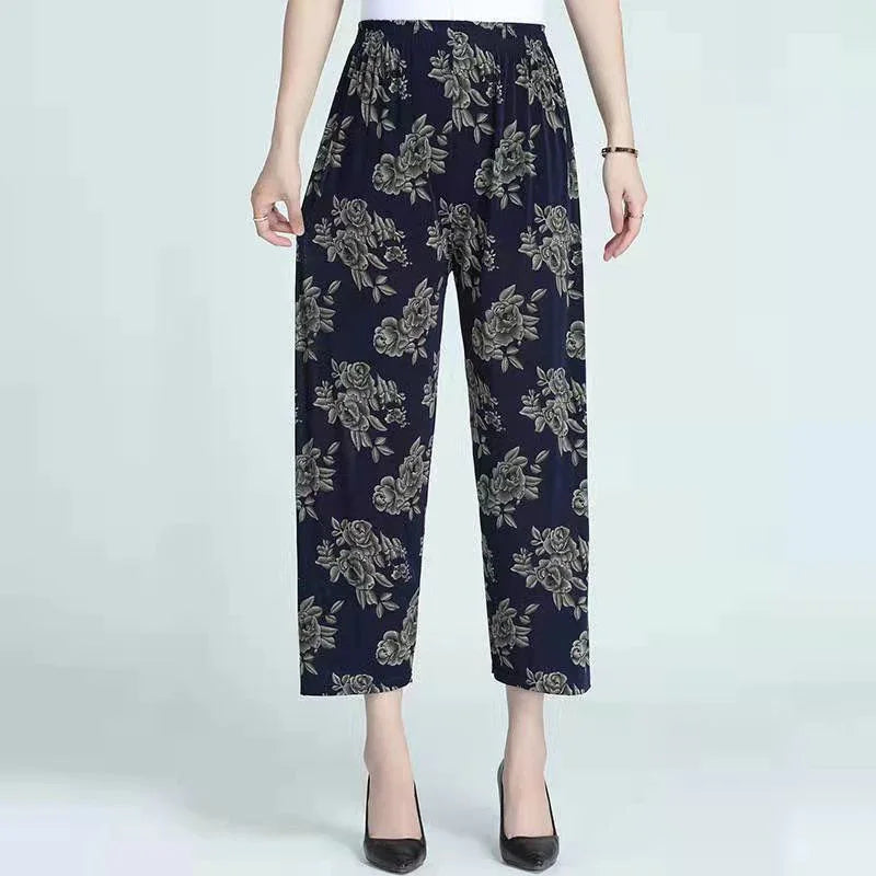 Women's navy blue floral print pants with elastic waist and black heels on light background