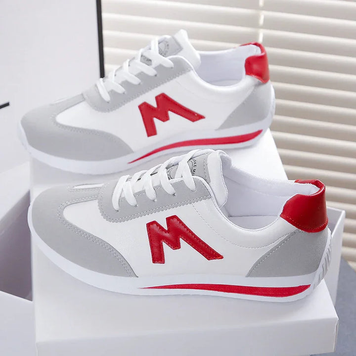 White and gray sneakers with red accents and 'M' logo on the side, displayed on white boxes