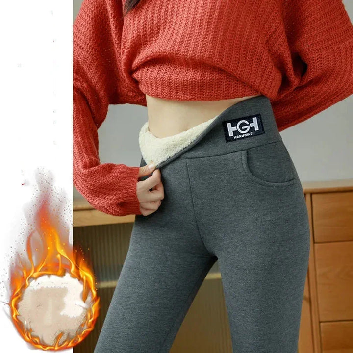 Close-up of gray fleece-lined leggings with warm fabric label, worn with textured red cropped sweater