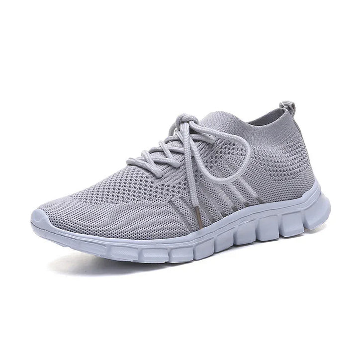 Light gray knit athletic sneaker with flexible segmented white sole and matching laces