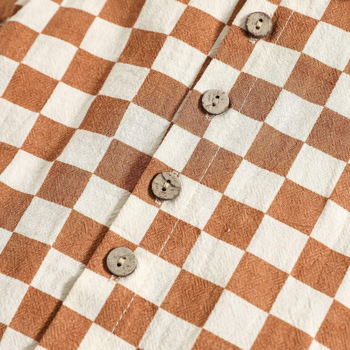 Close-up of brown and white checkered fabric with round wooden buttons