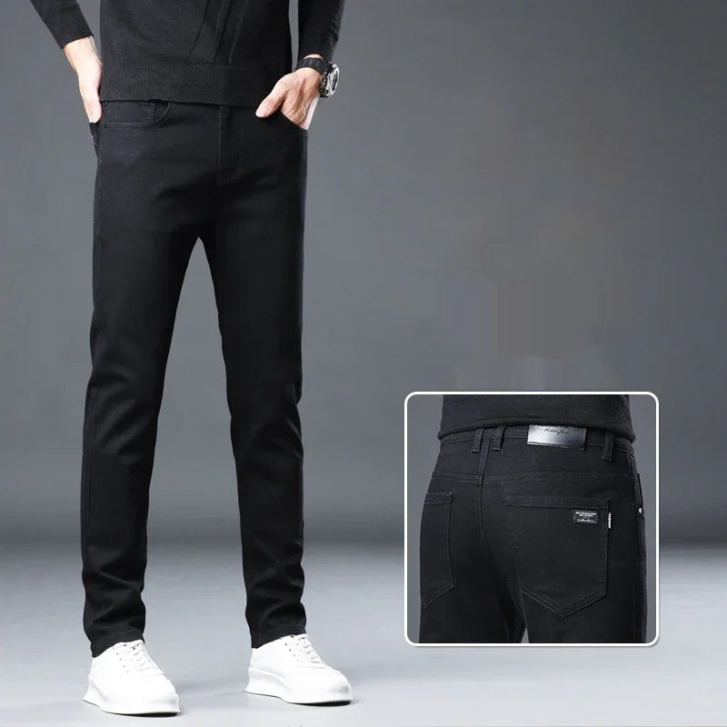Man wearing slim fit black jeans and white sneakers on grey background with back pocket detail