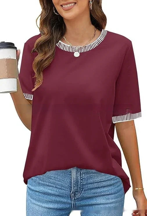 Woman wearing maroon short-sleeve top with striped collar and sleeve edges, holding coffee cup