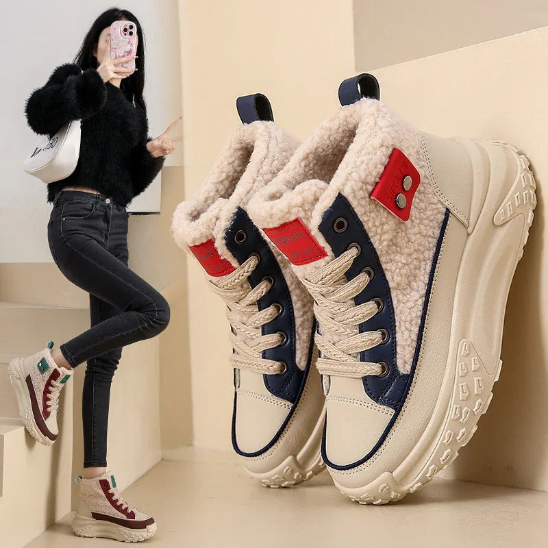 Chunky cream winter boots with shearling lining, navy and red accents, worn with black jeans