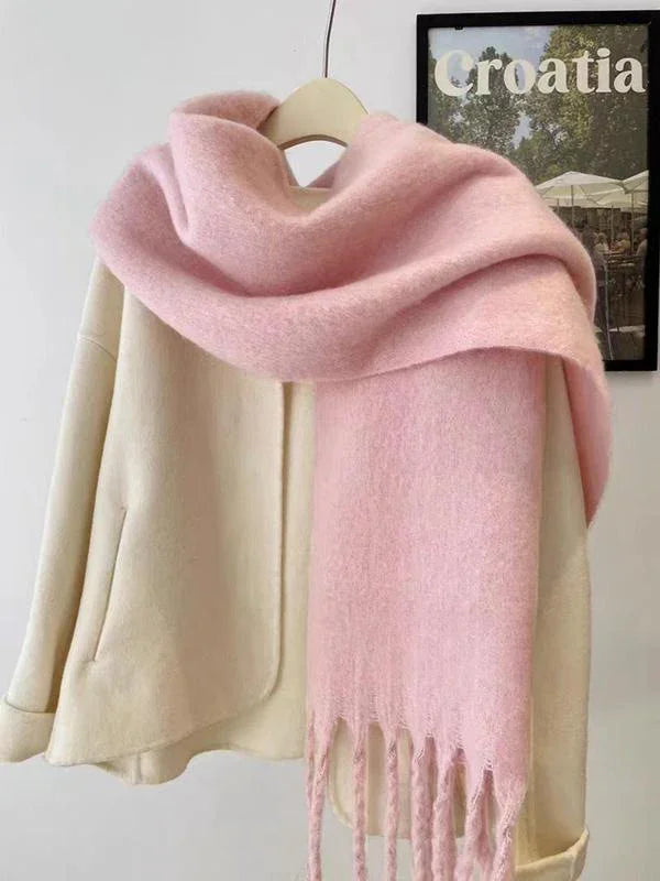 Cream coat with large soft pink fringed scarf draped over shoulders on hanger
