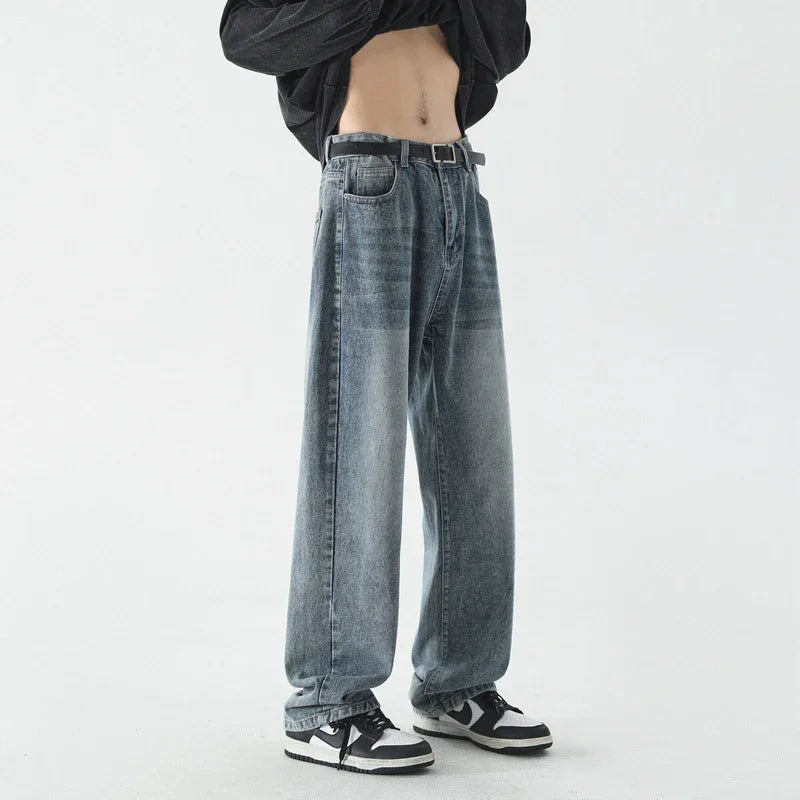 Casual faded blue baggy jeans with black belt worn with black and white sneakers