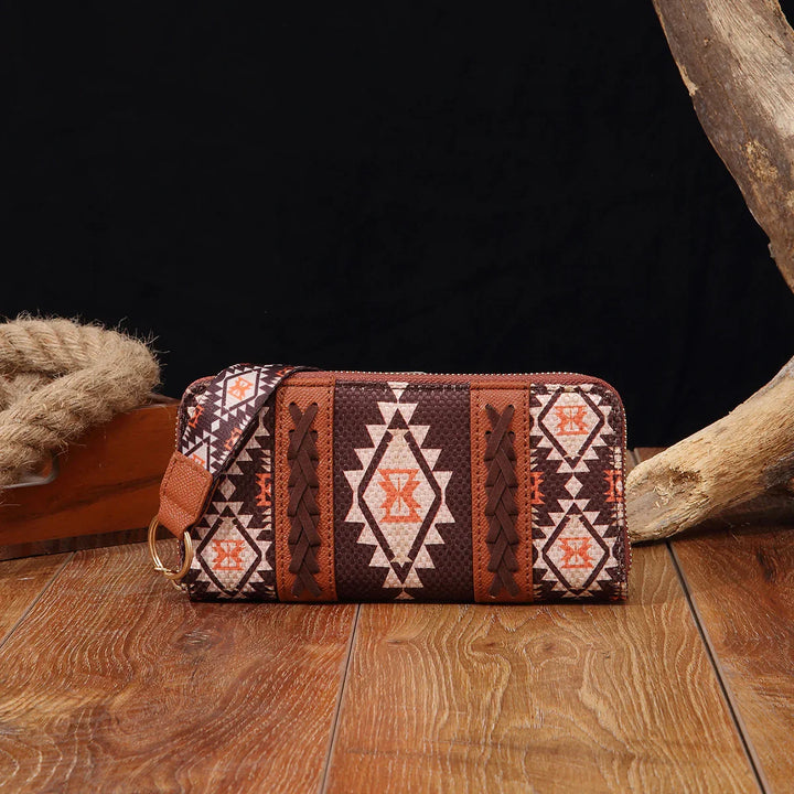 Boho-style zippered wallet with geometric tribal patterns in brown, orange, and beige on wooden floor