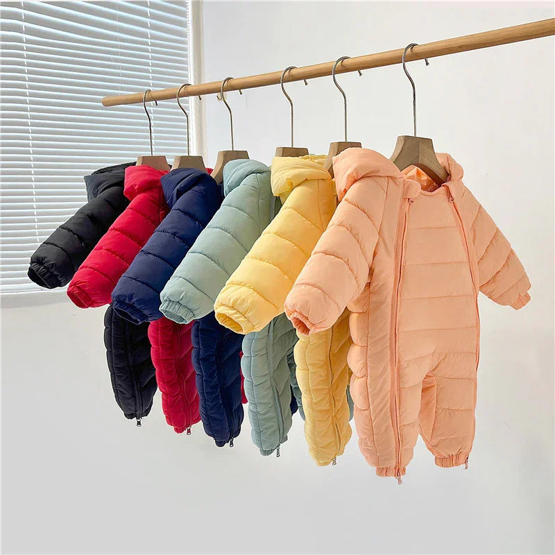Colorful baby padded winter jumpsuits with hoods hanging on wooden hangers in a row