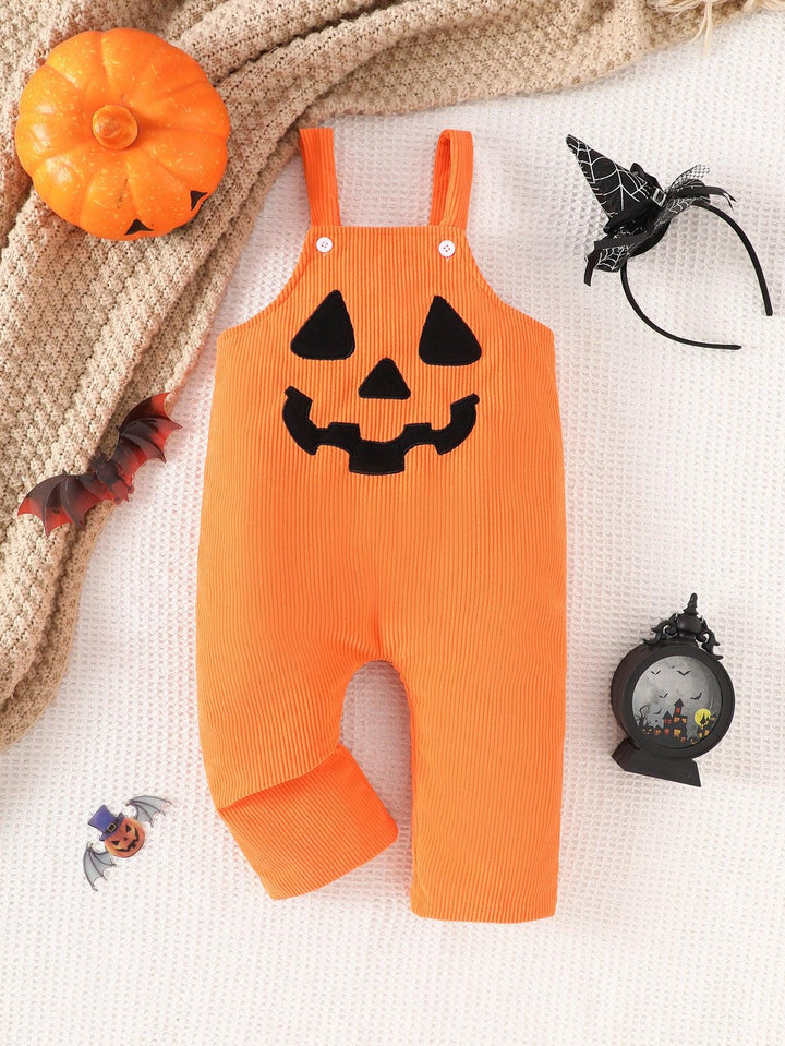 Orange baby romper with jack-o'-lantern face, surrounded by Halloween decorations including pumpkin, bat clips, witch hat headband, and spooky lantern