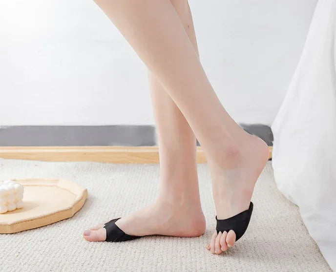 Woman's feet wearing black half socks on beige carpet in minimalist room