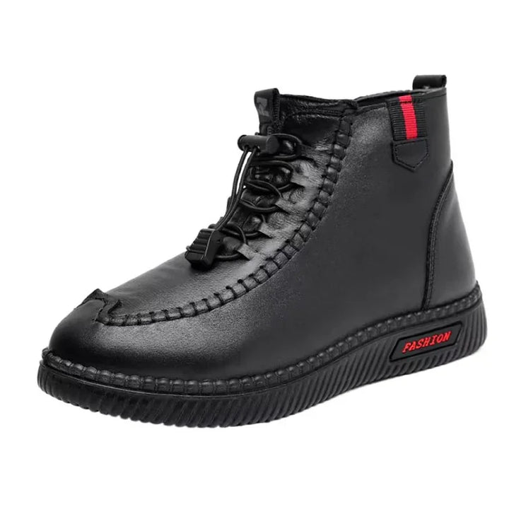 Black leather fashion ankle boot with red accents and stitched detailing