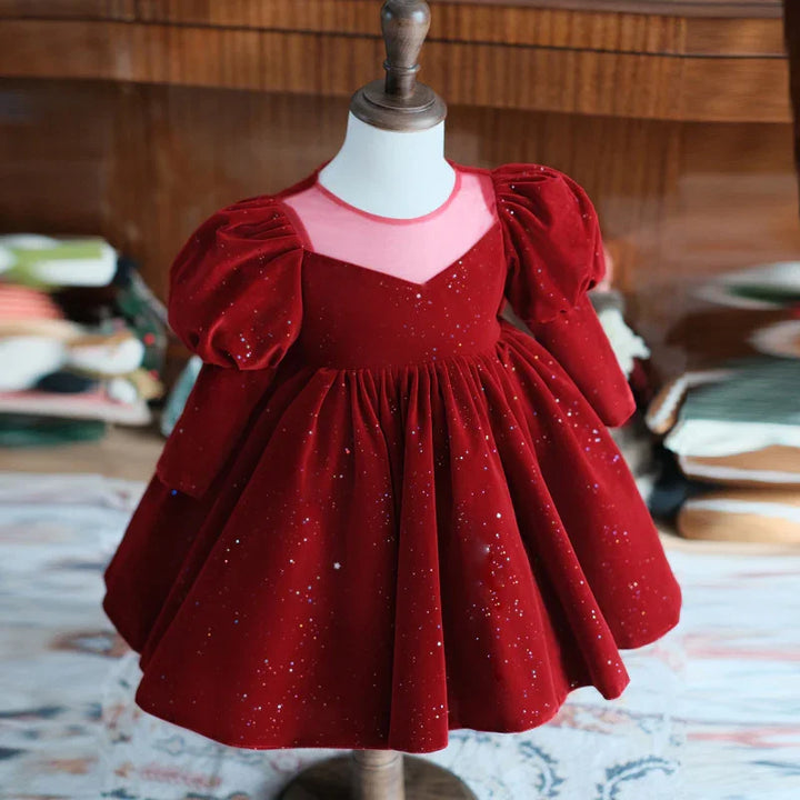Red velvet toddler dress with puff sleeves and glitter details on a wooden mannequin