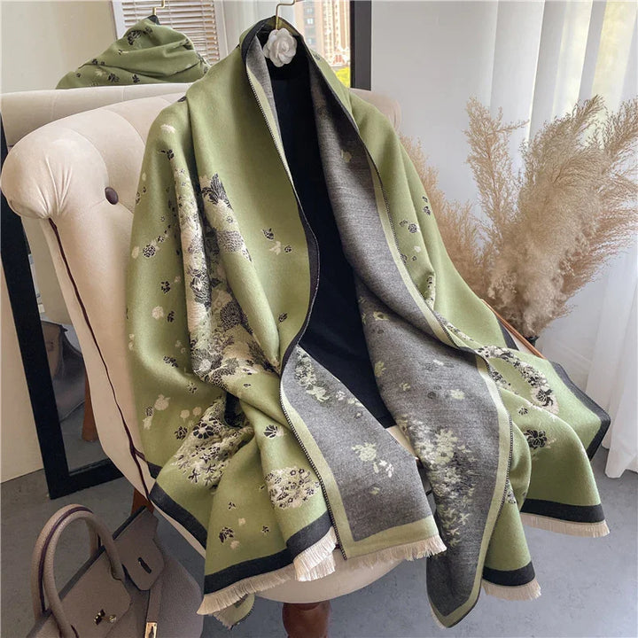 Elegant green and gray floral patterned wool shawl draped over beige armchair with brown leather handbag nearby