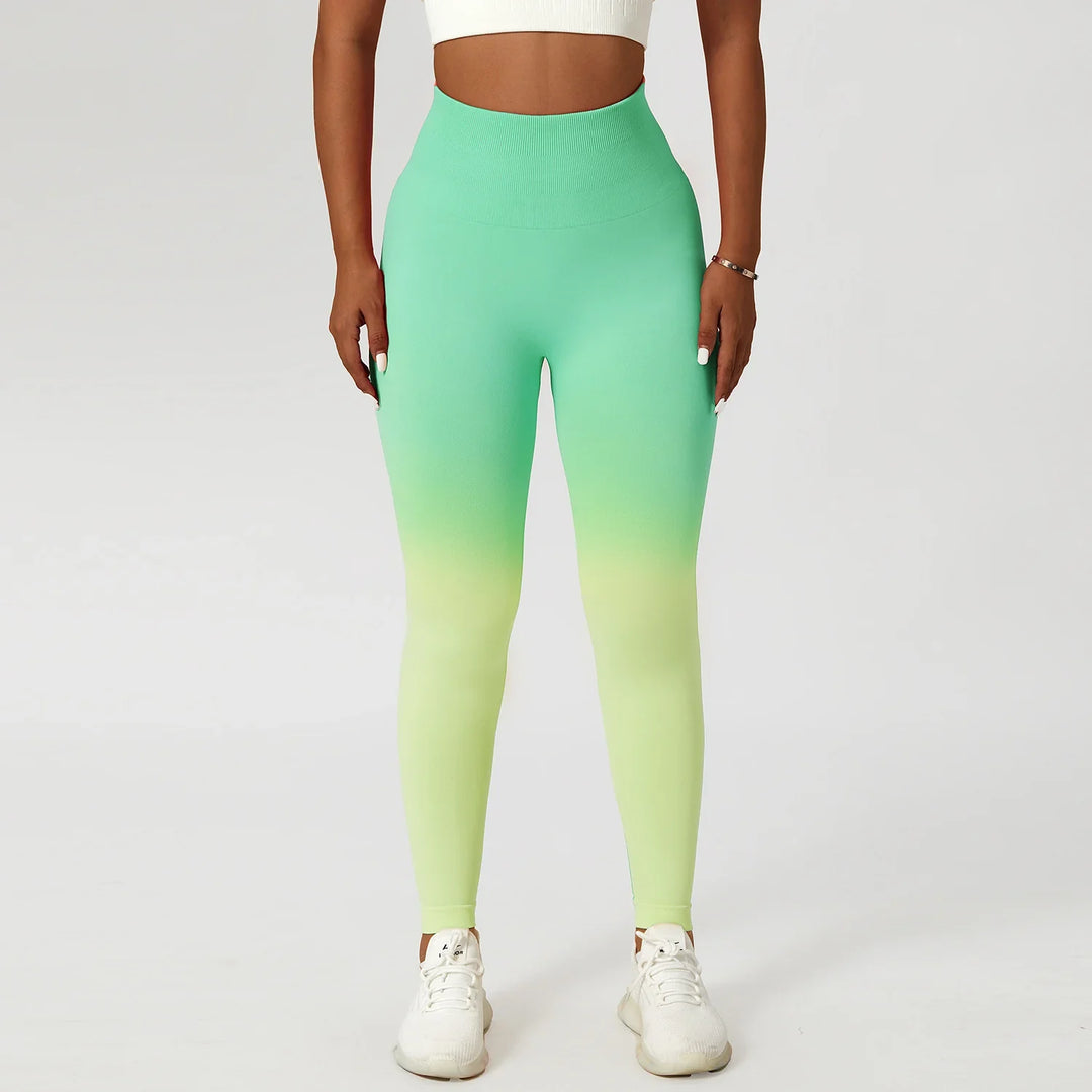 Woman wearing mint green ombre seamless leggings and white crop top on white background