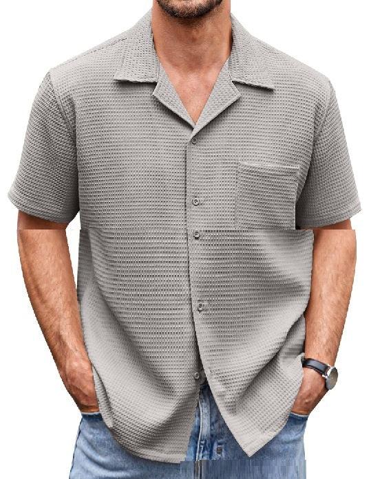 Man wearing light gray textured short sleeve button-up shirt with chest pocket and blue jeans