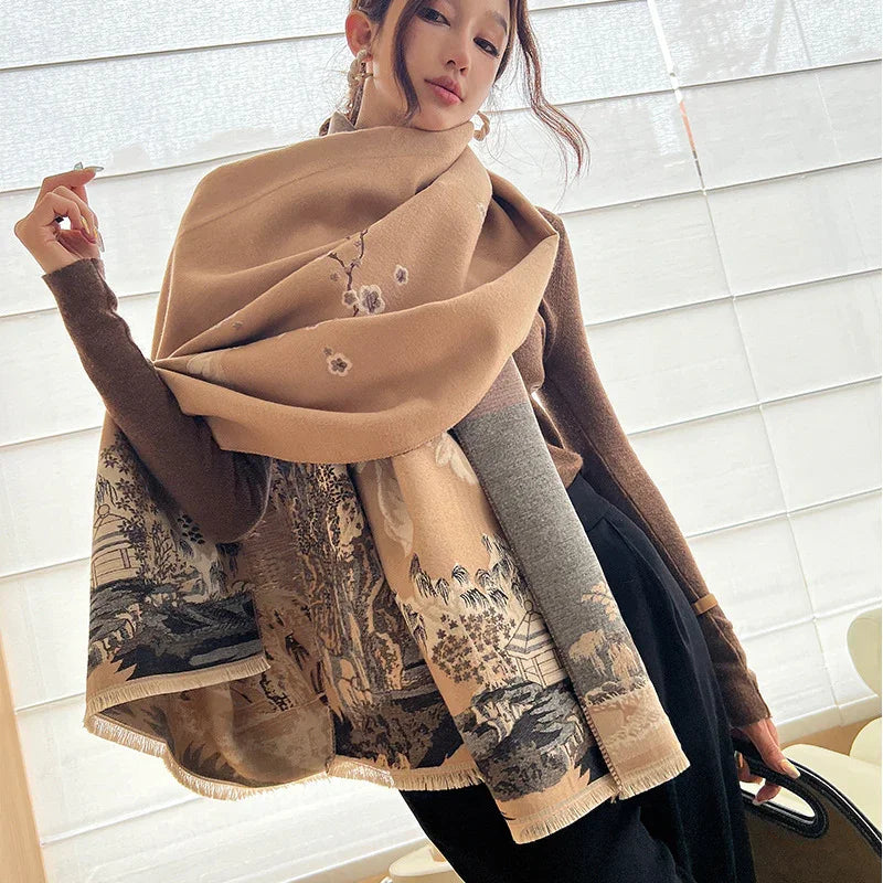 Woman wearing oversized brown scarf with intricate nature and floral patterns, paired with brown top and black pants