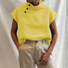 Person wearing a bright yellow sleeveless top with button details paired with beige pants