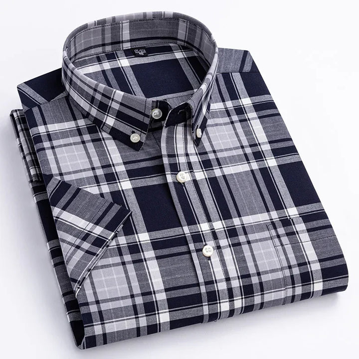 Folded navy blue and grey plaid short sleeve button-down shirt with white buttons
