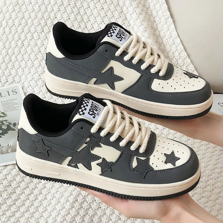Black and white star-patterned sneakers with thick white laces and black soles on knit fabric