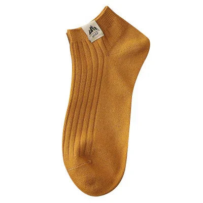 single mustard yellow ankle sock with ribbed texture and white brand label
