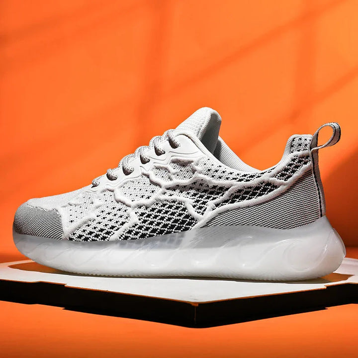 White and black knitted running sneaker with thick white sole on orange background
