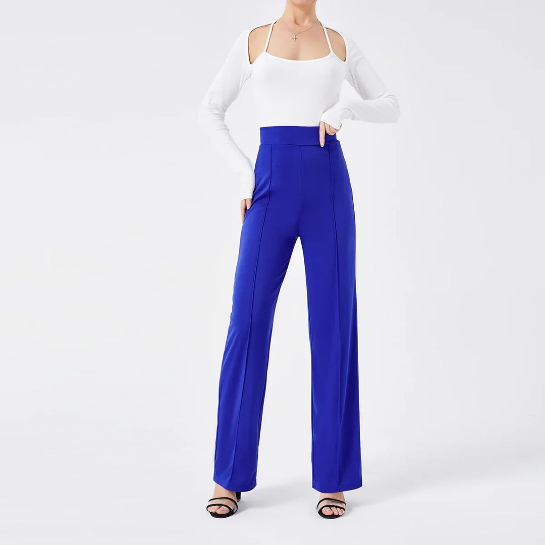 Woman wearing high-waisted royal blue wide-leg trousers and white cold-shoulder top with spaghetti straps