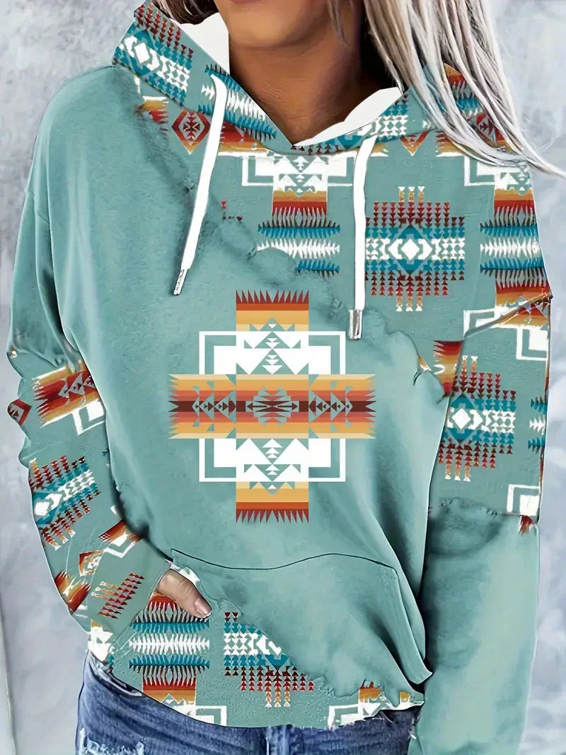 Woman wearing teal hoodie with colorful Native American geometric pattern and white drawstrings
