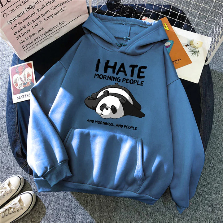Blue hoodie with panda graphic and text I hate morning people, surrounded by paper bag, books, and white sneakers