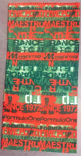 Colorful fabric with repeated text patterns in red, green, and white including 'FORMULA ONE', 'LIVE PC', 'MAESTRU', and 'SINCE 1972'