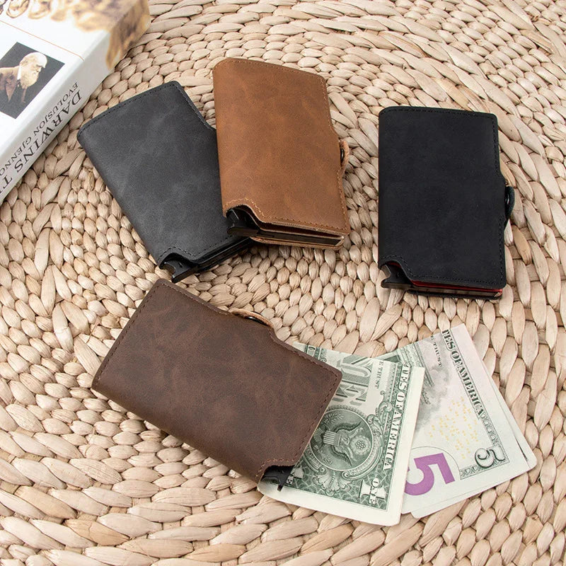 Four leather wallets in black, brown, and tan on woven mat with US dollar and five-dollar bills