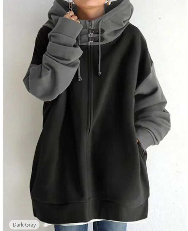 Woman wearing oversized black and dark gray zip-up hoodie with double buckle hood and long sleeves
