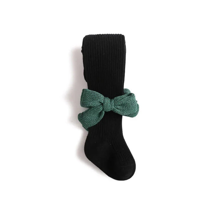 Black ribbed knee-high sock with green textured fabric bow accessory on white background