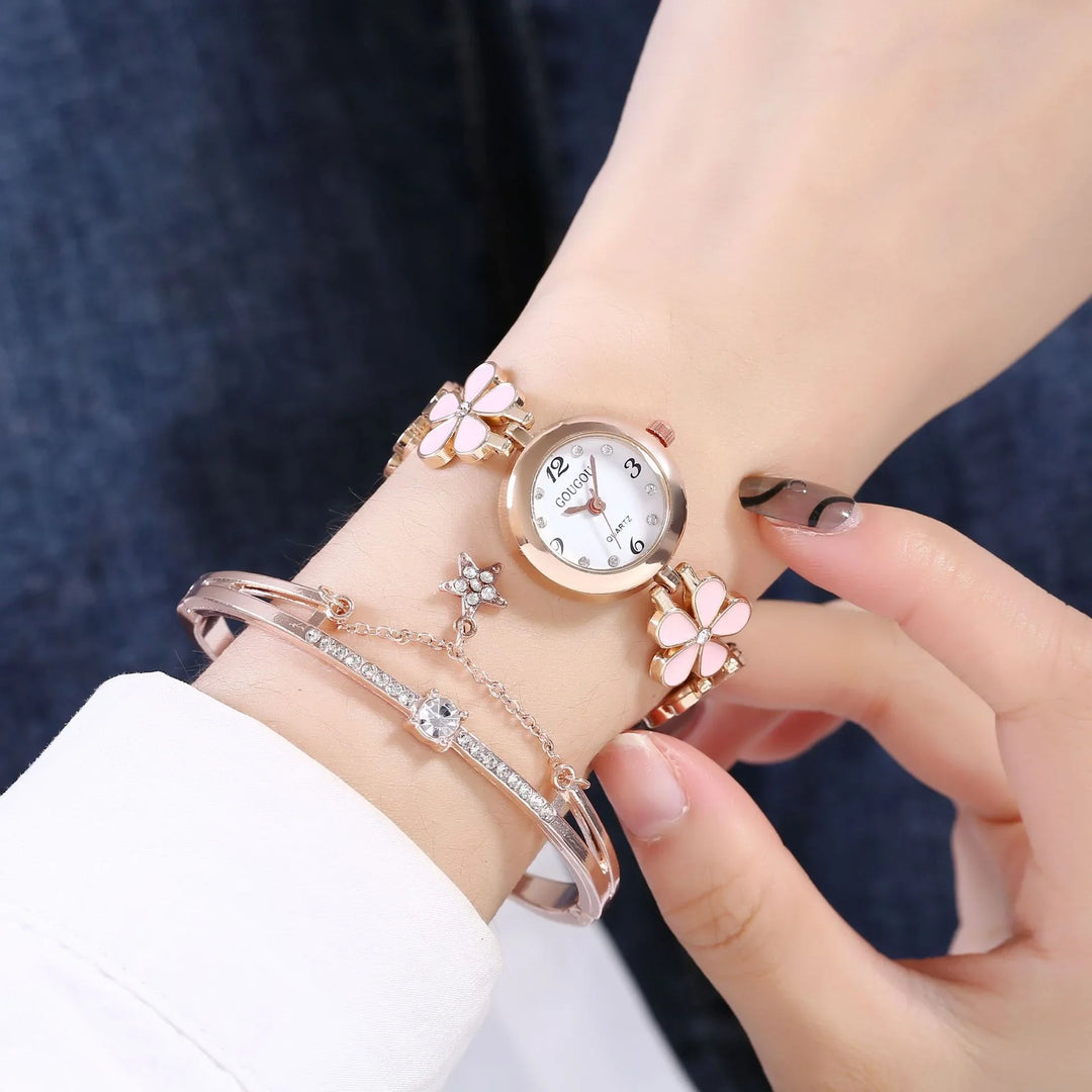 Elegant rose gold wristwatch with pink flower charms and rhinestone bracelet on wrist