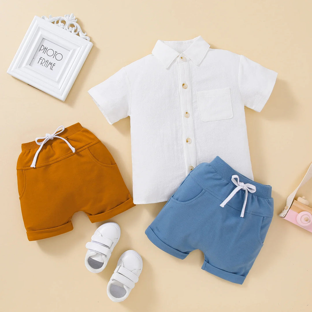 Toddler summer outfit set with white short-sleeve shirt, mustard and blue shorts, white sneakers on beige background