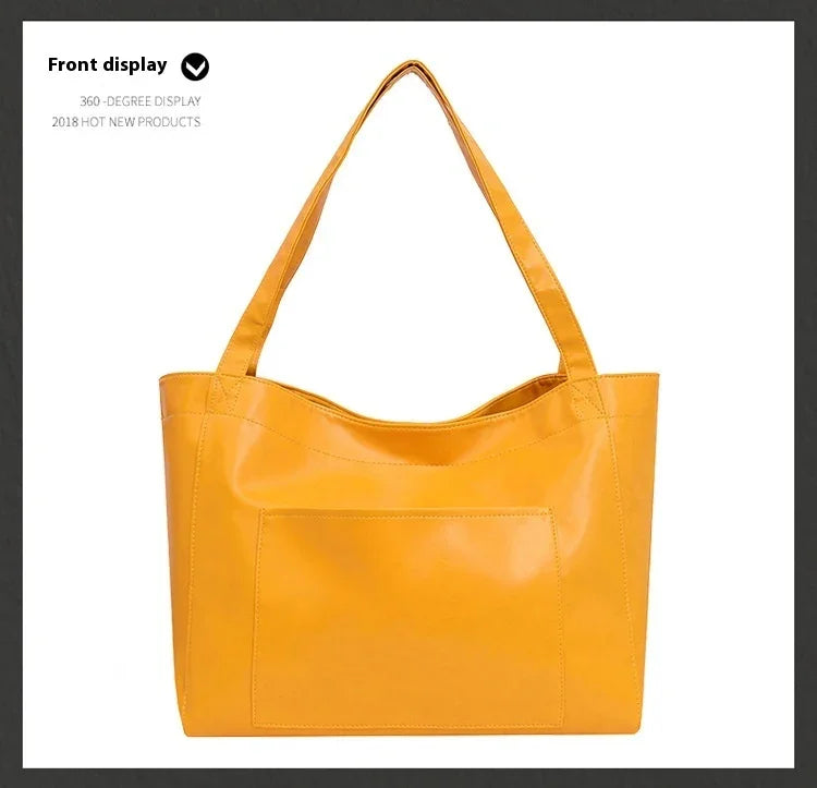 Front view of a yellow leather tote bag with double shoulder straps and a front pocket