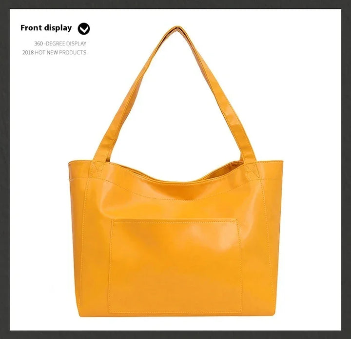 Front view of a yellow leather tote bag with double shoulder straps and a front pocket