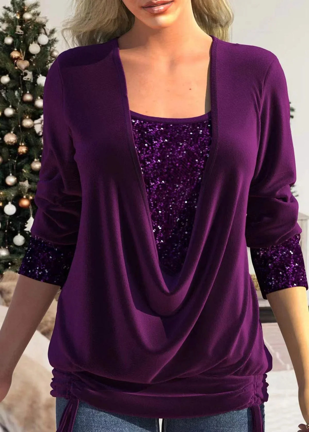 Woman wearing purple sequin layered top and blouse with Christmas tree in background