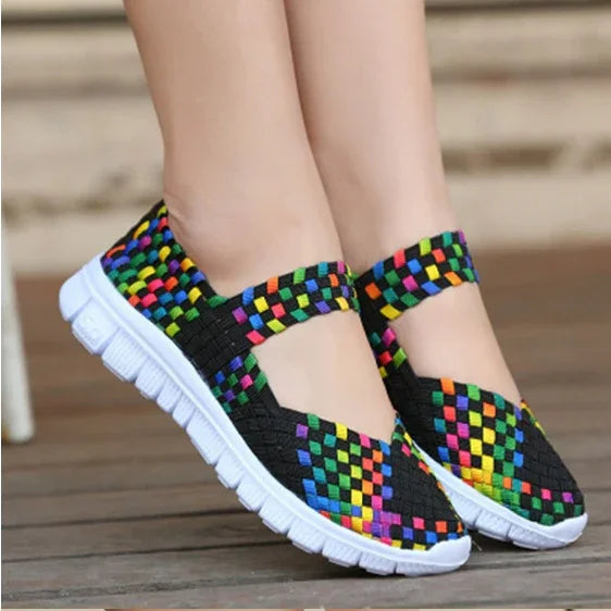 colorful woven slip-on casual shoes with white flexible soles on wooden floor