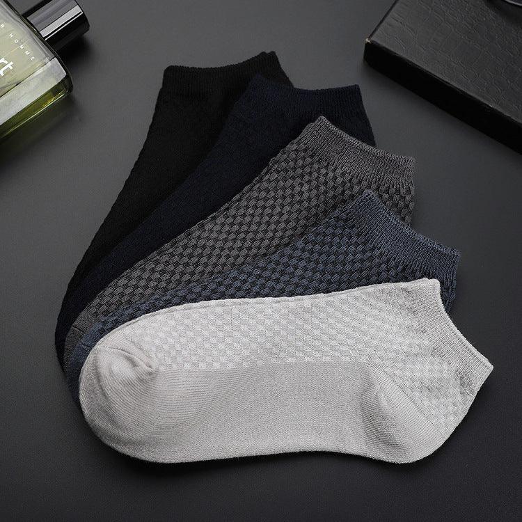Set of five ankle socks in black, navy, grey, dark blue, and light grey with textured pattern on a dark surface