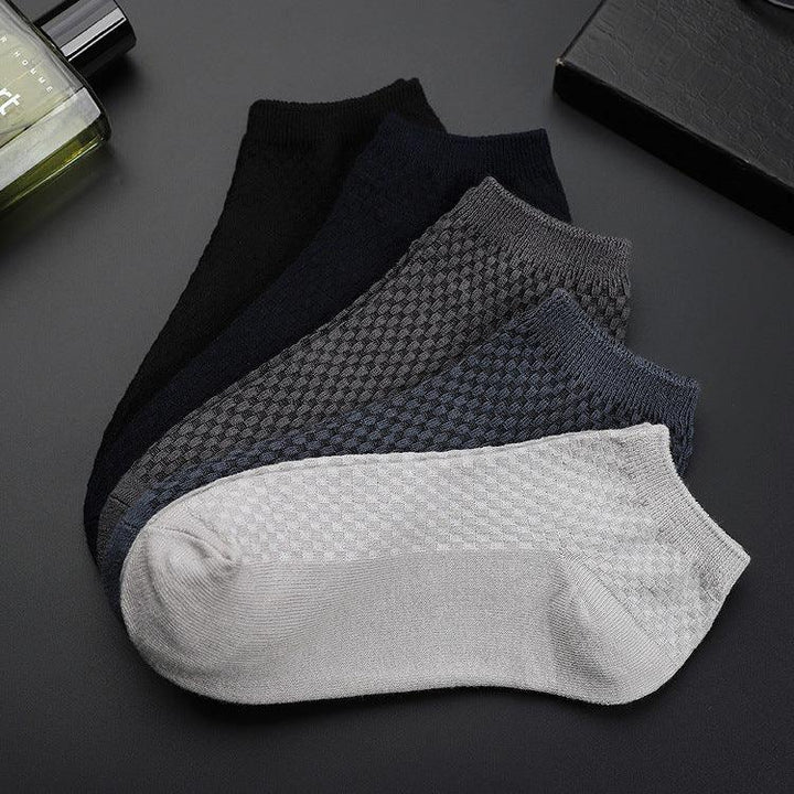 Set of five ankle socks in black, navy, grey, dark blue, and light grey with textured pattern on a dark surface