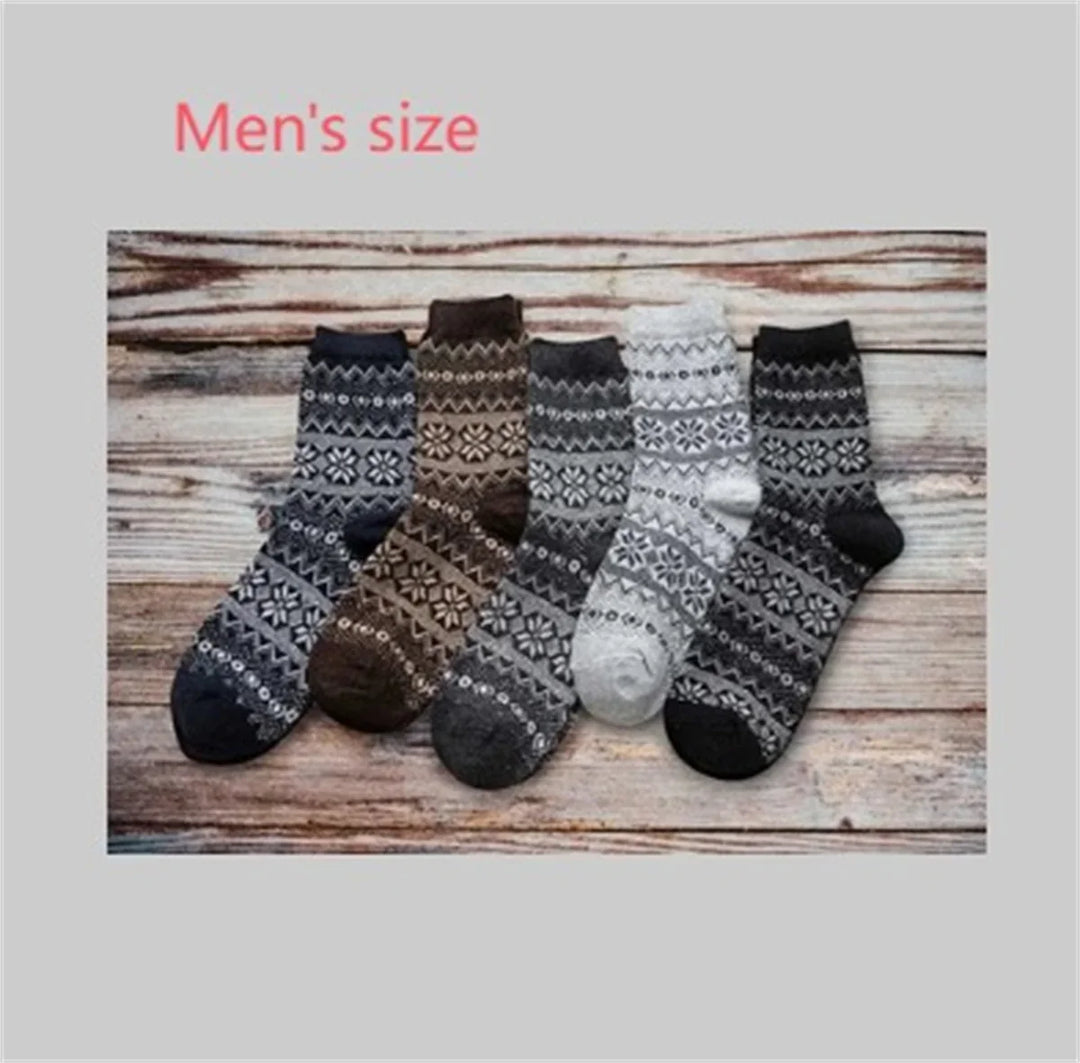 Men's size wool socks with snowflake patterns in black, brown, gray, white on wooden surface