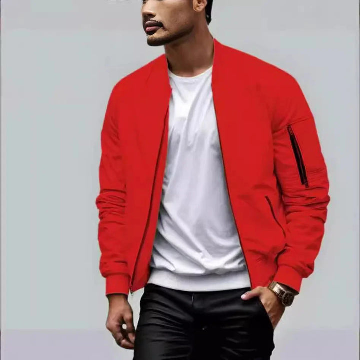 Man wearing a bright red bomber jacket over a white T-shirt and black pants with a gold watch
