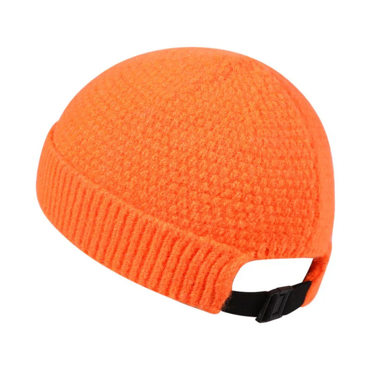 Orange textured knit beanie with ribbed cuff and adjustable black strap on white background