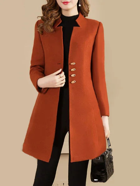 Woman wearing rust orange long wool coat with four buttons and black outfit holding black handbag
