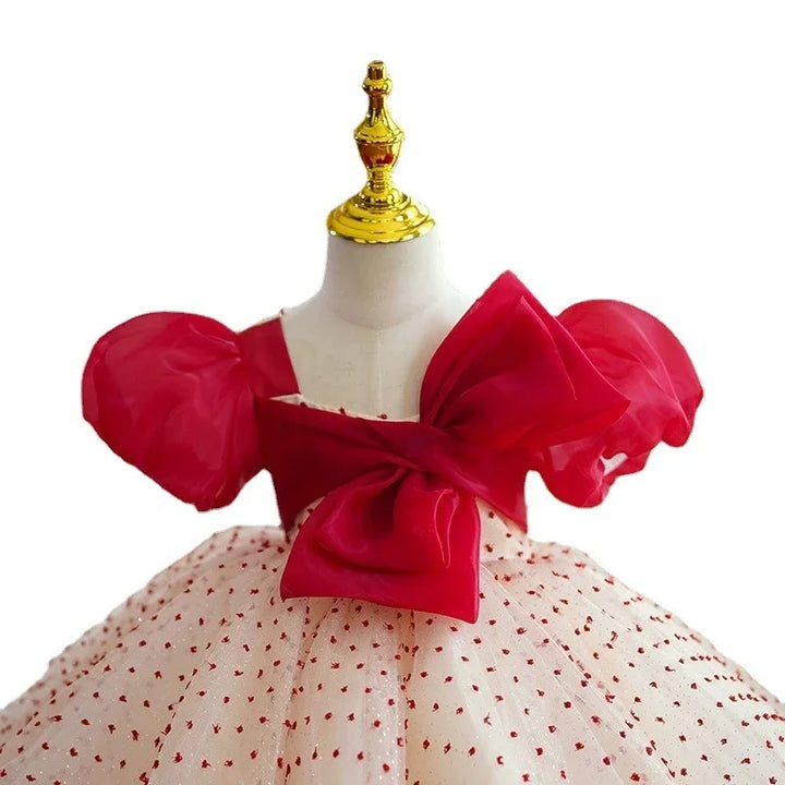 Red and white baby dress with puff sleeves, large bow, and polka dot skirt on mannequin