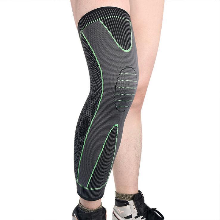 Gray knee compression sleeve with green accents worn on leg, athletic shoes visible