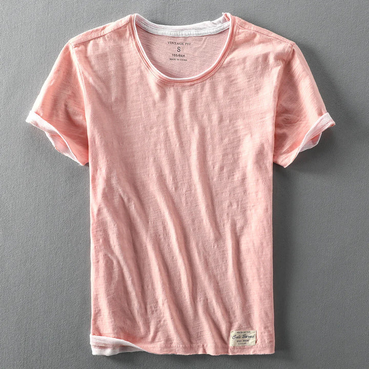 Pink vintage fit cotton t-shirt with rolled sleeves on gray background